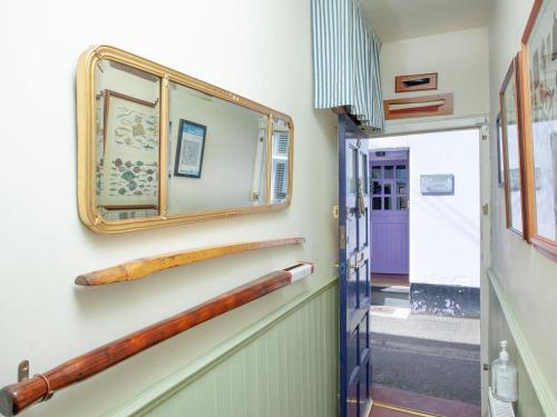 un pasillo con dos bates de béisbol en la pared en Tillerman Cottage appledore Devon, en Appledore