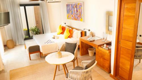 a room with a bed and a table and chairs at Wonders Beach Boutique Hotel in Mont Choisy