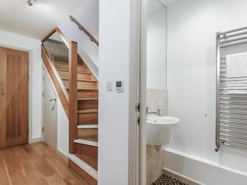 a bathroom with a sink and a staircase at Buzzard in Blackawton