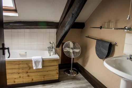 a bathroom with a tub and a sink and a fan at White Hart Inn in Bouth