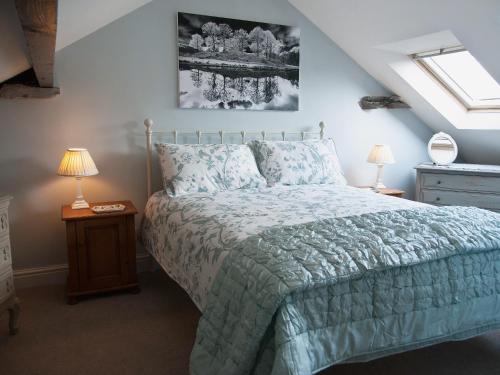 a bedroom with a bed and two lamps and a window at Bowfell in Ambleside