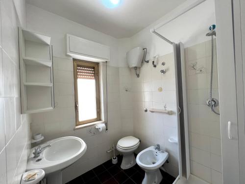 a white bathroom with a sink and a toilet at Residence Atlante in Leporano