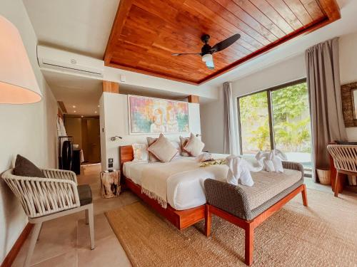 a bedroom with a bed and a chair and a ceiling at Wonders Beach Boutique Hotel in Mont Choisy