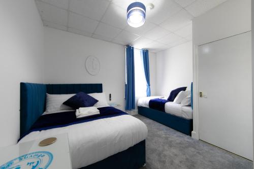 a bedroom with two beds with blue and white at The New Apollo Hotel in Blackpool