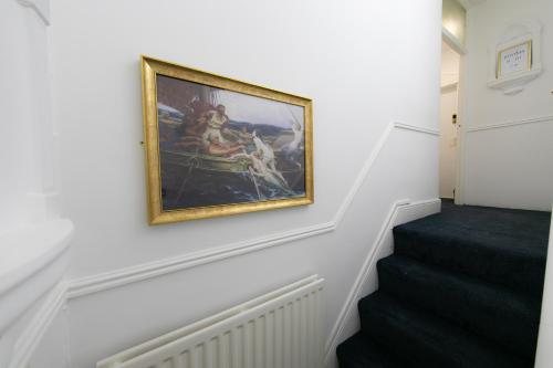 a painting hanging on a wall next to a staircase at The New Apollo Hotel in Blackpool