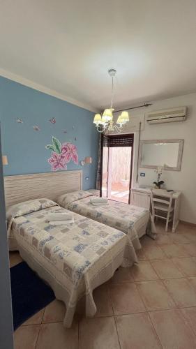 a bedroom with two beds and a window at Hotel Tabby in Golfo Aranci