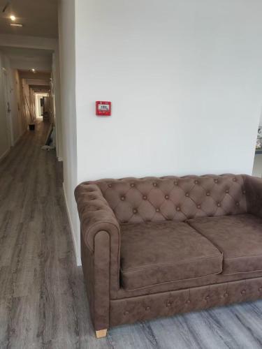 a brown couch sitting in a living room at HOSTAL GOLDEN 21*** in Madrid