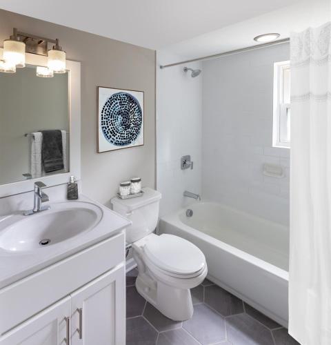 a white bathroom with a toilet and a sink at Grazus ir modernus garazas prie Vilniaus centro in Vilnius