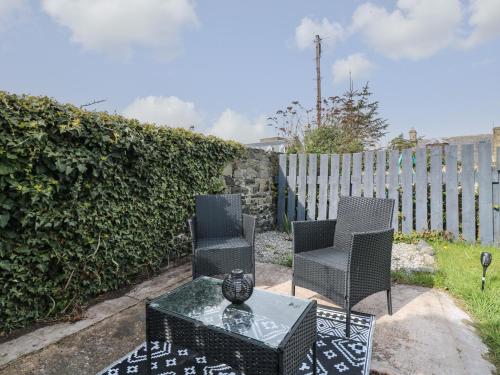 two chairs and a table and a fence at RockStar Cottage in Macduff