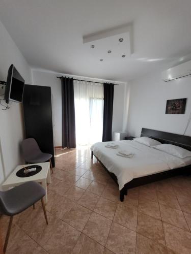 um quarto com uma cama grande e uma cadeira em Casa Patryk em Orşova