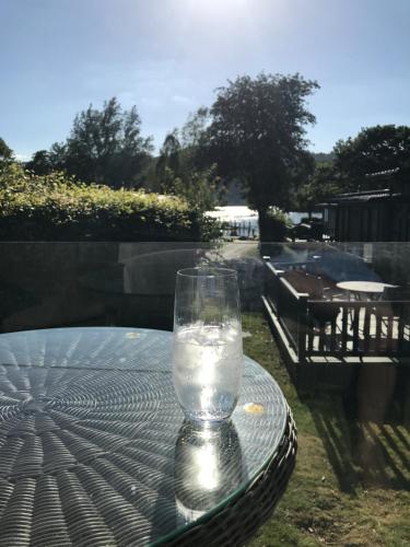 un vaso de agua sentado en una mesa en R11 Lake View, Fallbarrow Holiday Park, en Bowness-on-Windermere