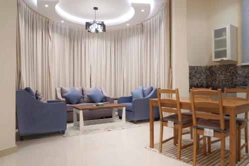 a living room with a couch and a table and chairs at سما الرفاع 3 in Al Kharj