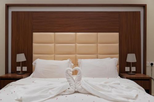 a bedroom with a bed with white sheets and pillows at سما الرفاع 3 in Al Kharj