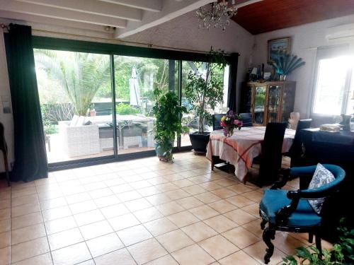 a living room with a table and a large sliding glass door at VILLA Zaphira in Gujan-Mestras