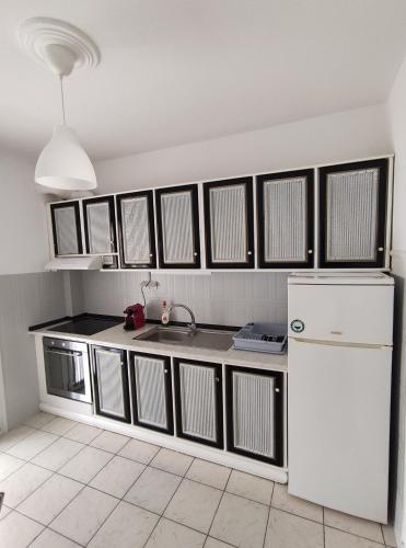 La cuisine est équipée d'un évier et d'un réfrigérateur blanc. dans l'établissement Helena's Apartment 2 Agia Triada, à Thessalonique