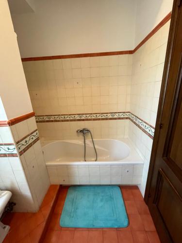 a bath tub with a blue mat in a bathroom at La casa nel villaggio dei pescatori in Spadafora