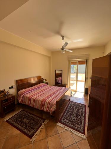 a bedroom with a bed and a ceiling fan at La casa nel villaggio dei pescatori in Spadafora