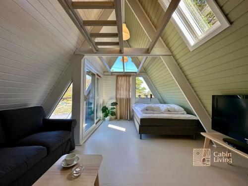 um quarto com uma cama, um sofá e uma televisão em Fantastic Sea Cottage on Justøya Island, Lillesand em Lillesand