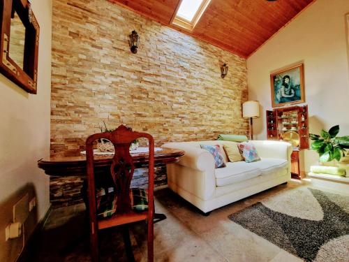 a living room with a white couch and a brick wall at Casa das Azenhas by Lisbon Village Apartments in Sintra