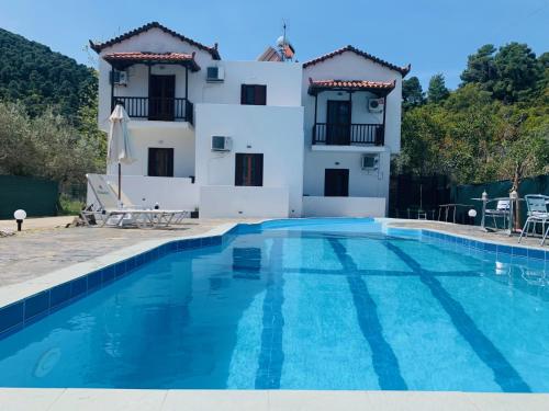 a villa with a swimming pool and a house at Skopelos Inn in Stafylos