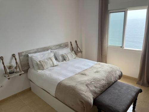 Un dormitorio con una cama grande y una ventana en Apartamento a pie de playa con vistas al mar. en Sorvilán