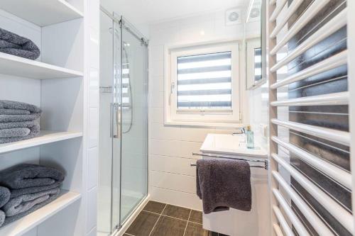 uma casa de banho branca com um chuveiro e um lavatório. em Hausboote am Bärwalder See Traumhaus-mieten em Klitten