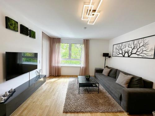 a living room with a couch and a tv at 10 minutes to the center, 2 minutes to the metro in Vienna