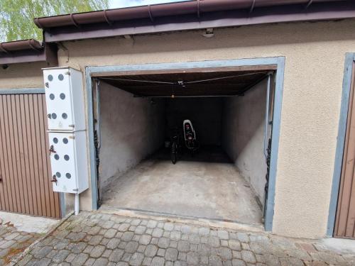 a garage with a door open with a motorcycle in it at Apartament Helenka in Hajnówka