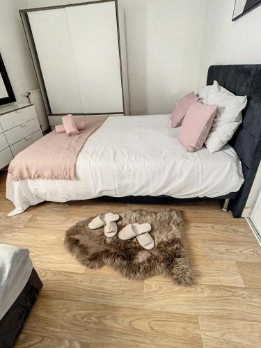 a bedroom with a bed with shoes on the floor at Grand Appartement Paris et Disneyland 4pers in Neuilly-sur-Marne