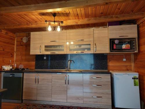 a kitchen with wooden cabinets and a sink and a refrigerator at MEVA APART in Rize