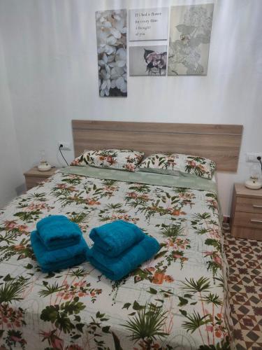 a bed with two blue pillows on top of it at Estudio Alicia in Rota