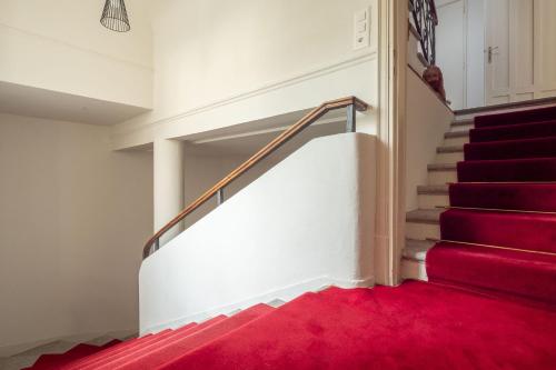 a staircase with a red carpet in a house at Villa by @ Home Hotel Locarno in Locarno