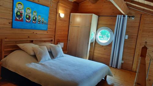 ein Schlafzimmer mit einem Bett in einem Holzzimmer in der Unterkunft La Datcha d'Elena in La Chapelle-de-Guinchay