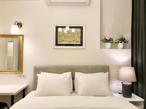 a bedroom with a bed with white pillows and a mirror at MY FABULOUS SPRlNG HOME lN TAKSlM in Istanbul