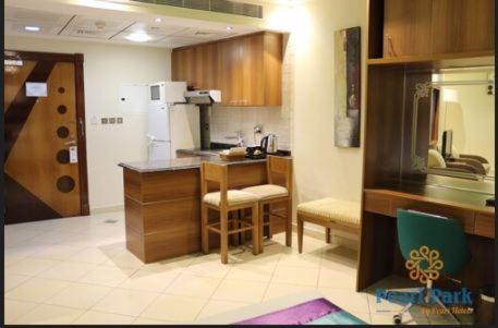 eine Küche mit Holzschränken und einem weißen Kühlschrank in der Unterkunft Pearl Executive Hotel Apartments in Dubai