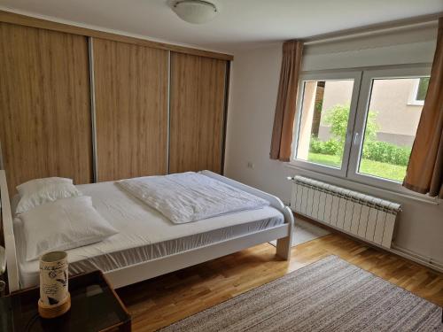 um quarto com uma cama branca e uma janela em Big 70m2 apartment with free parking em Belgrado
