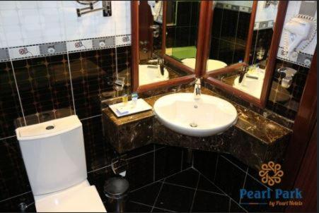 a bathroom with a white toilet and a sink at Pearl Executive Hotel Apartments in Dubai