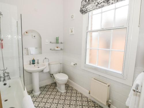 a white bathroom with a toilet and a sink at 4 The Old Council House in Shipston on Stour