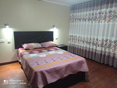 1 dormitorio con cama y cortina en Casa Hospedaje VIRREY, en Jauja