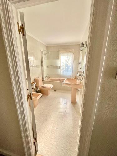 a bathroom with a sink and a toilet and a tub at La Casa de la Buganvilla in Gijón