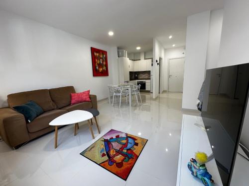 een woonkamer met een bank en een tafel bij Magnificent and New apartment in Playa San Juan in Guía de Isora