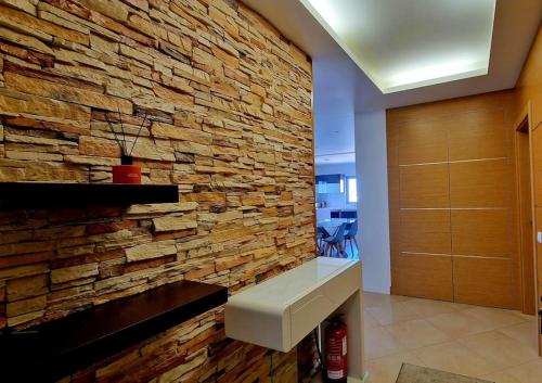 un mur en pierre dans une pièce dotée d'un banc contre elle dans l'établissement Deluxe 2 bedroom apartment with BBQ, à Lagos