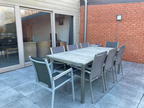 a wooden table and chairs on a patio at Het Zonnetje Zonnebeke in Zonnebeke