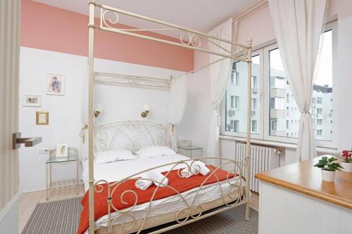 a bedroom with a metal bed in a room with a window at University Apartment in Bucharest