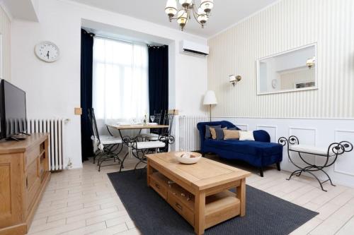 a living room with a blue couch and a table at University Apartment in Bucharest