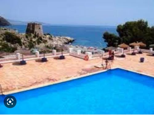 una piscina azul con vistas al océano en Balcón al mediterráneo, en Almuñécar