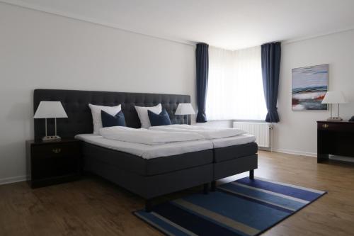a bedroom with a large bed with blue pillows at Helnan Phønix Hotel in Aalborg