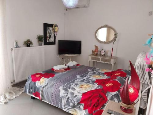 een slaapkamer met een bed met rode bloemen erop bij Ellie's apartment in Athene