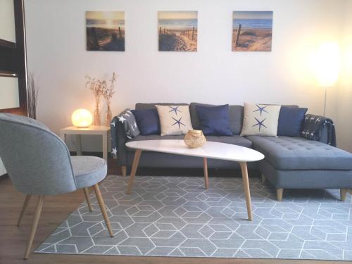 ein Wohnzimmer mit einem Sofa, einem Tisch und Stühlen in der Unterkunft Ferienwohnung am Ellerbach in Hessisch Oldendorf