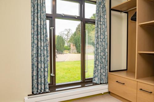 a room with a window with curtains and a dresser at The Cosener's House in Abingdon